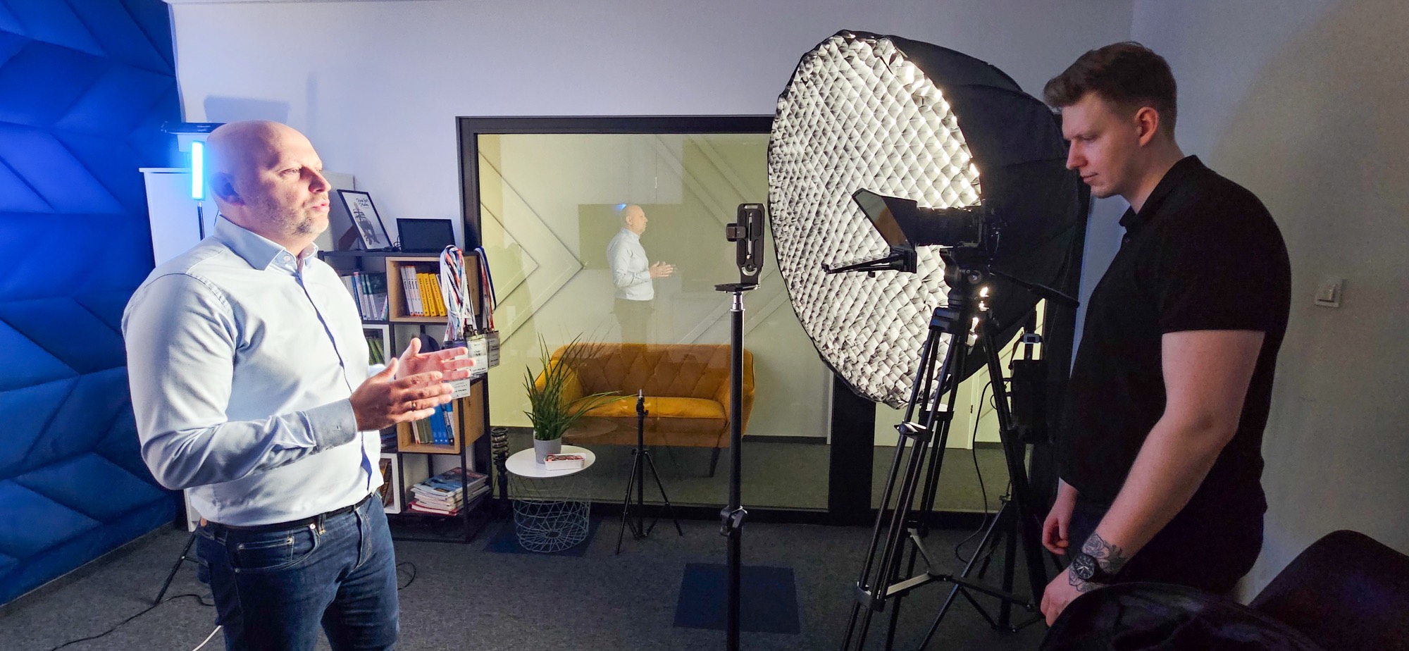 Dawid Marszał na planie zdjęciowym: klient mówi do kamery, obok softbox i statywy